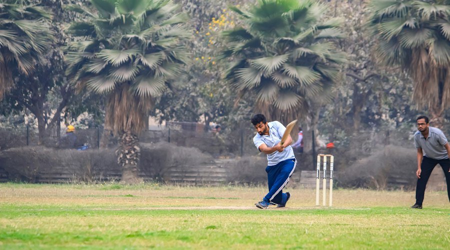 Cricket player batting on an open field