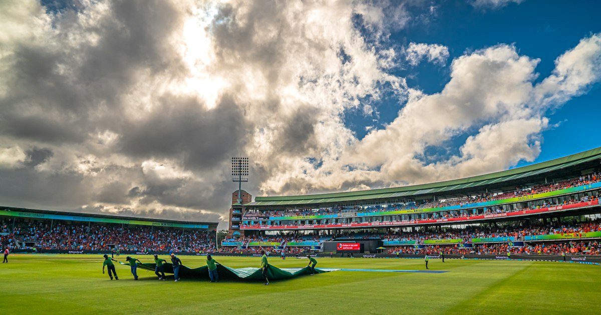 Cricket ground prepared during rainy match conditions